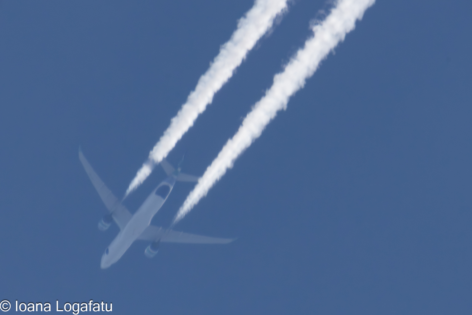Contrails dance across a bright blue sky